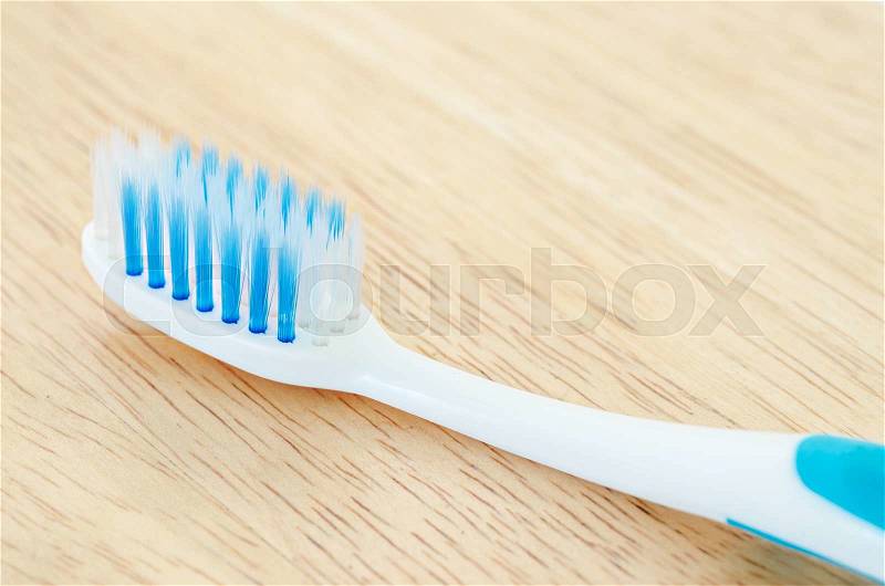 Close up blue color toothbrush on wooden background, stock photo