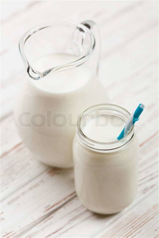 Milk jar on a wooden table, stock photo