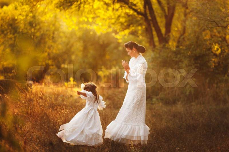 Mother and little daughter playing together in a park, stock photo