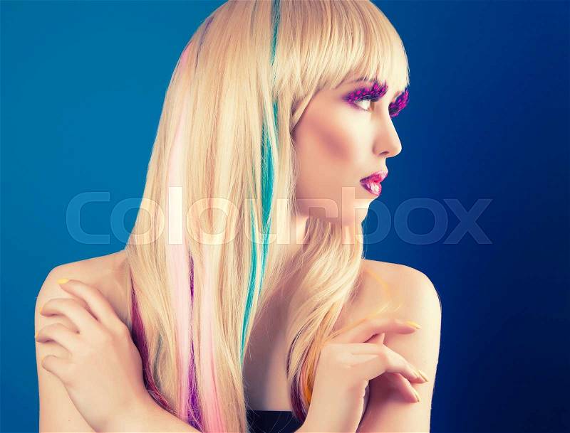 Beautiful young woman with blonde hair against blue background, stock photo