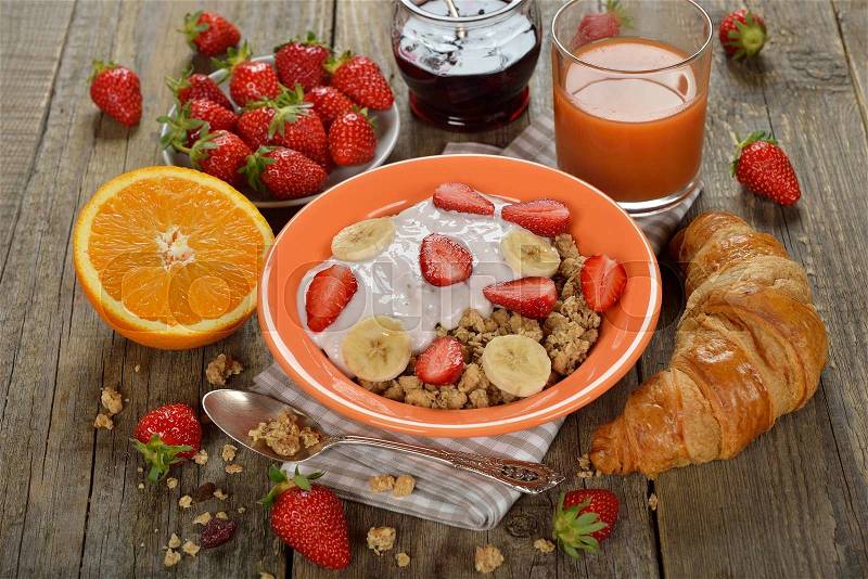 Muesli with yogurt, croissant and fresh strawberries for breakfast, stock photo