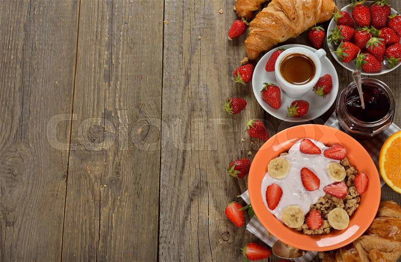 Muesli with yogurt, croissant and fresh strawberries for breakfast, stock photo