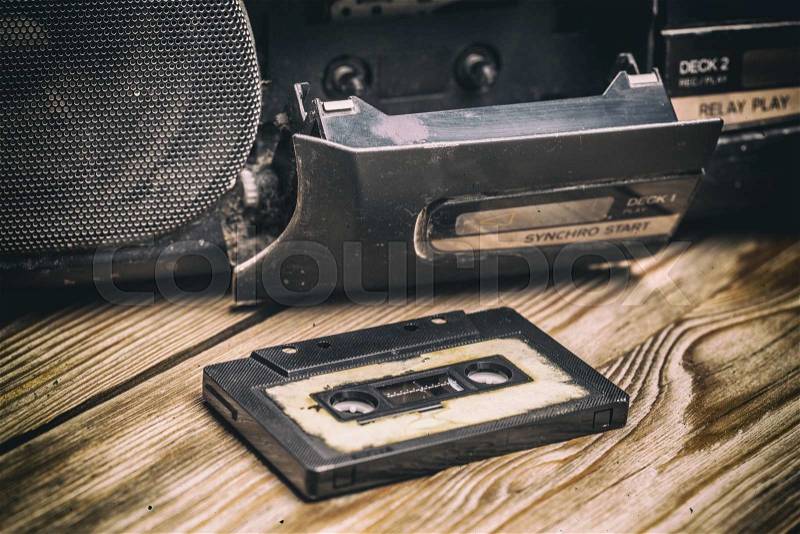 Old cassette tape and player on the old brown wooden background, stock photo