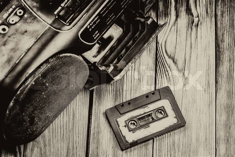 Old cassette tape and player on the old brown wooden background, stock photo