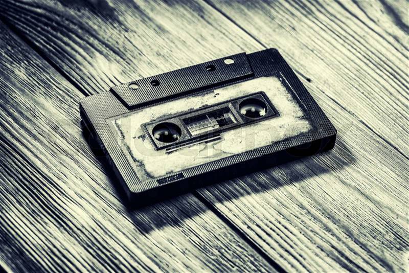 Old audio cassette on a brown wooden background, stock photo