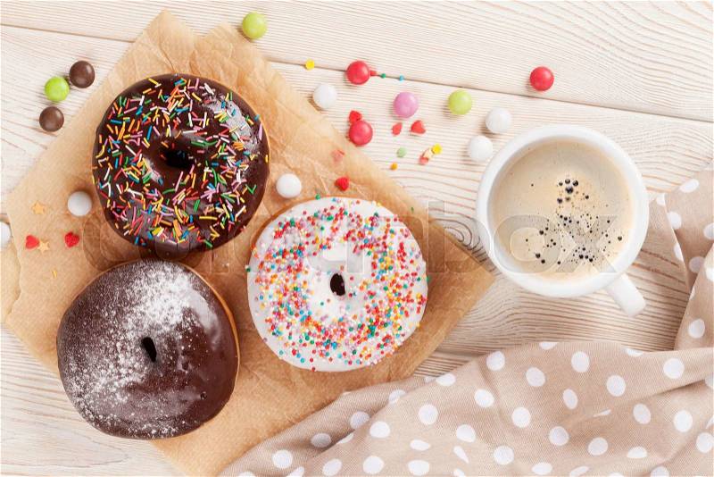 Donuts and coffee on wooden table. Top view, stock photo
