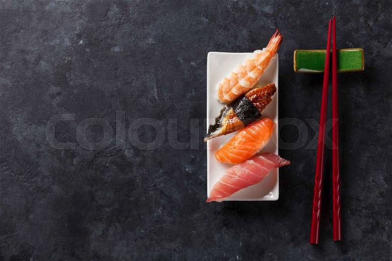 Sushi set and chopsticks on stone table. Top view with copy space, stock photo