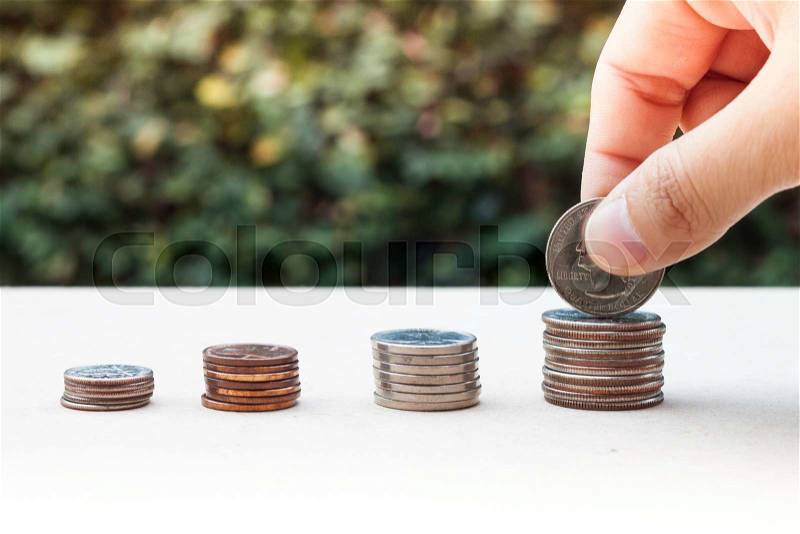 Woman hand putting money coin for saving money concept, stock photo