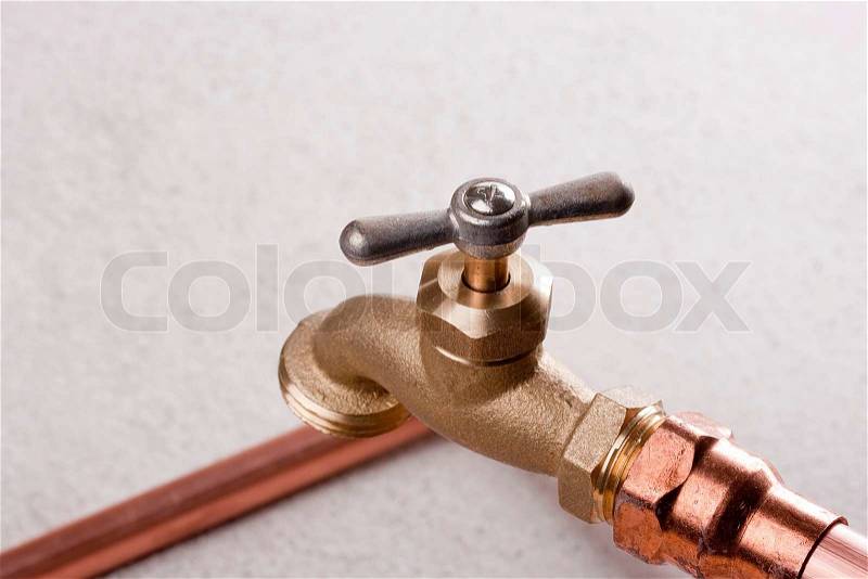 Bronze faucet attached to the water system of copper pipes, stock photo