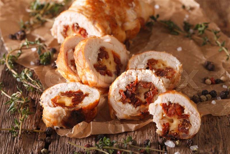 Chicken roll stuffed with cheese and sun-dried tomatoes close-up on the table. Horizontal , stock photo