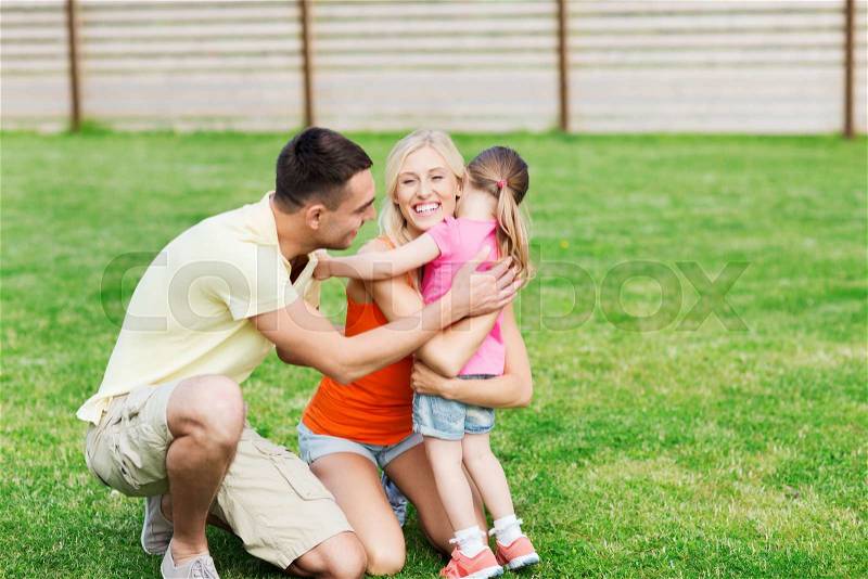 Family, happiness, adoption and people concept - happy family hugging outdoors, stock photo
