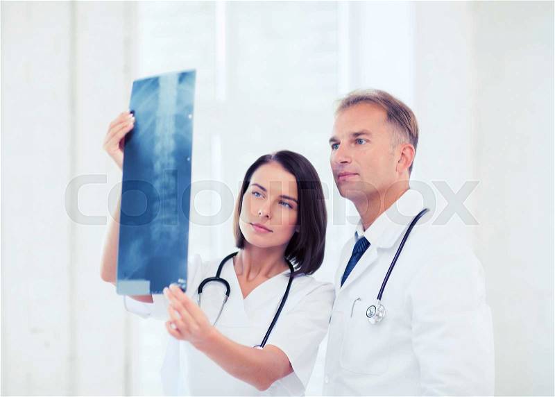 Healthcare, medical and radiology concept - two doctors looking at x-ray, stock photo