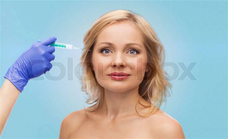 Beauty, anti-aging cosmetic surgery concept - smiling woman face and beautician hand in glove with syringe making injection to eye contour area over blue background, stock photo