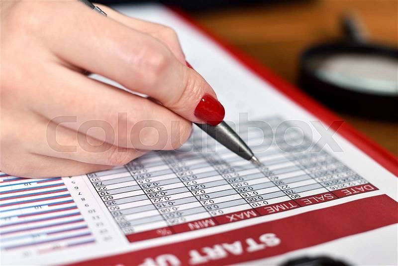 Businesswoman hand checks start up report. close up, stock photo