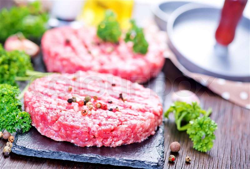 Raw burgers on board with salt and spice, stock photo