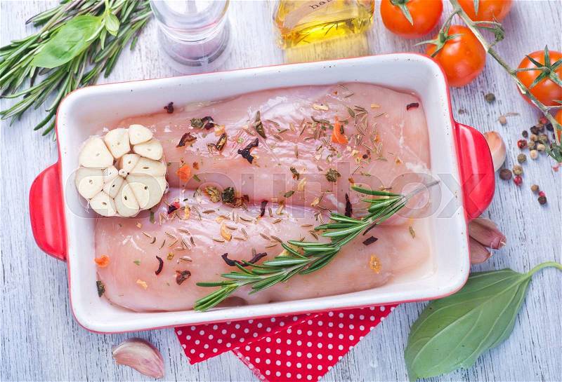 Raw chicken in bowl with salt and spice, stock photo