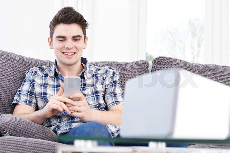 Man Streams Music From Mobile Phone To Wireless Speaker, stock photo