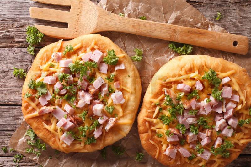 Hungarian pancakes langos with ham and cheese close-up on the table. horizontalview from above , stock photo