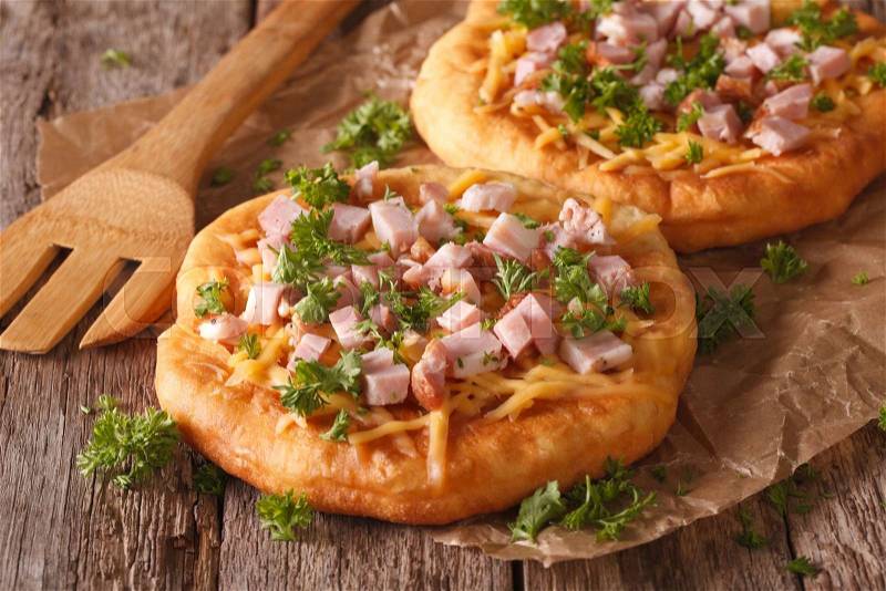Hungarian pancakes langos with ham and cheese close-up on the table. horizontal , stock photo