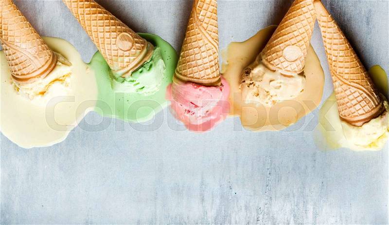 Colorful ice cream cones of different flavors. Melting scoops. Top view, copy space, steel metal background, stock photo