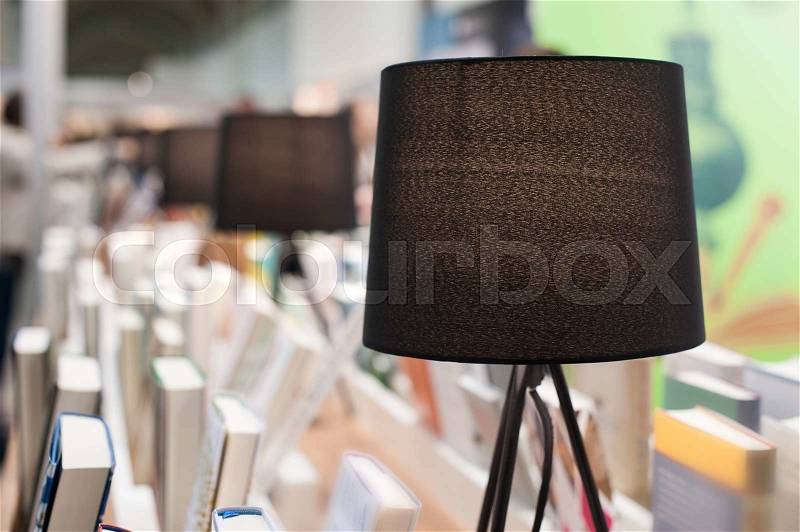 Electric brown table reading lamp and books in a library, stock photo