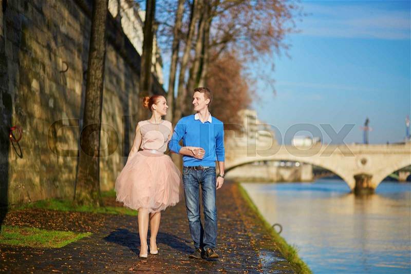 Young romantic couple on the Seine embankment in Paris, France, stock photo
