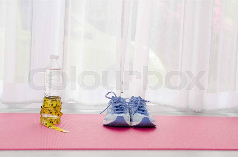 Sport shoes, yoga mat, bottle of water and centimeter on wooden background. Sport equipment. Concept healthy life. Selective focus, stock photo