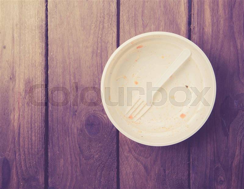 Empty dish after food on white wood,top view ,vintage color toned image, stock photo