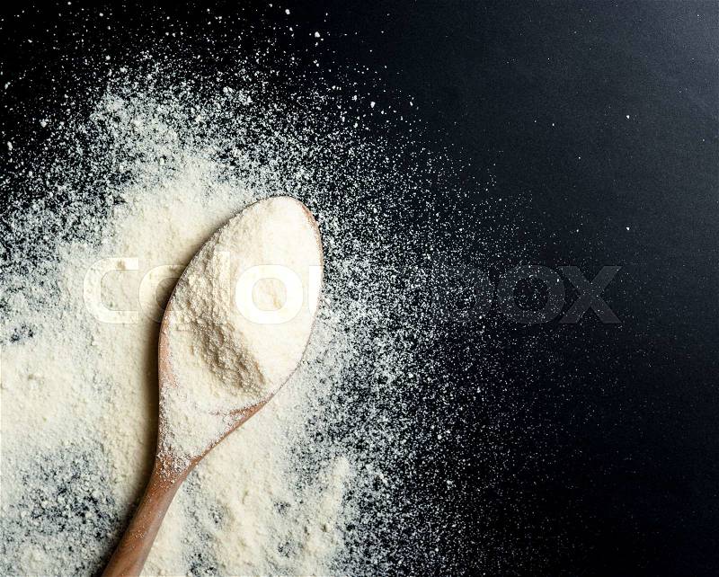 Close up of powdered milk and spoon for baby on a black slate, stock photo