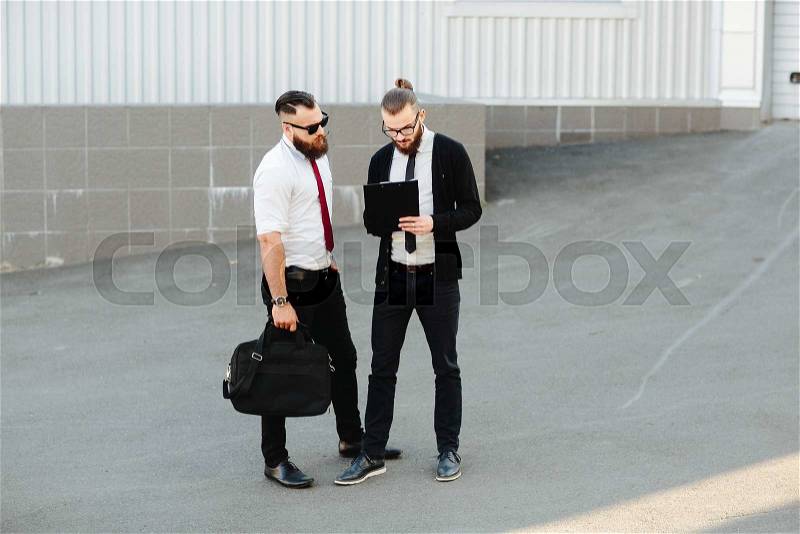 Two bearded businessman working on the street, stock photo