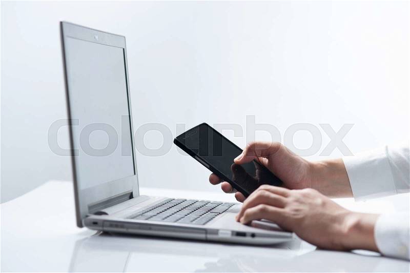 Business man hands busy working on his laptop and using smart phone on white background, stock photo