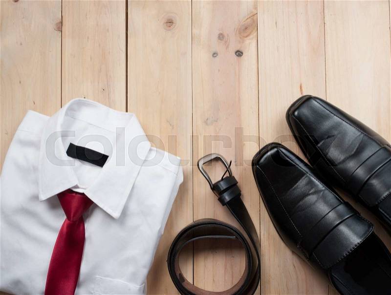Man\'s style accessories,shirt with a bright tie, shoes and a belt on wooden background, stock photo