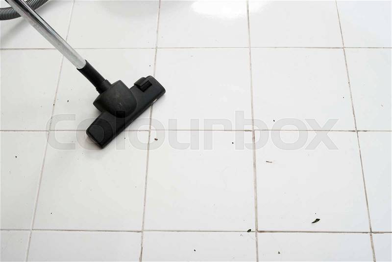 Vacuum cleaning dirt on a tiled floor, stock photo
