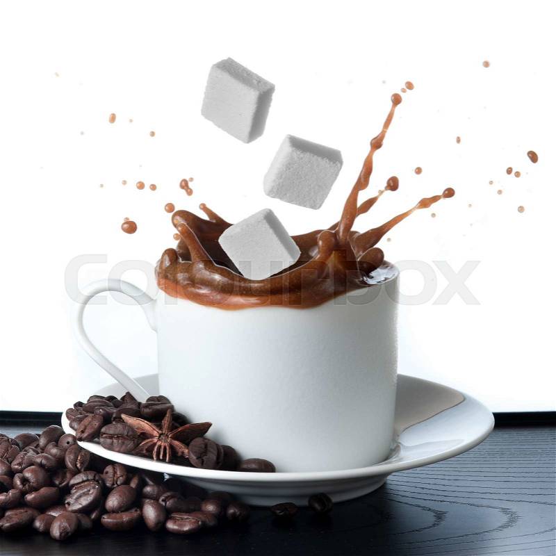 Cup of coffee with falling sugar cube isolated on white background, stock photo