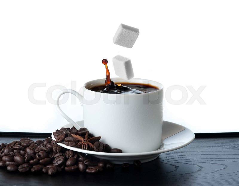 Cup of coffee with falling sugar cube isolated on white background, stock photo