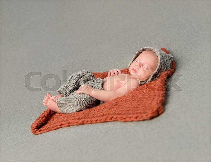 Little newborn baby sleeping on knitted blanket top view, stock photo