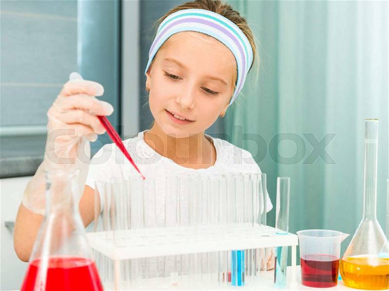 Cute little girl with flasks for chemistry, stock photo