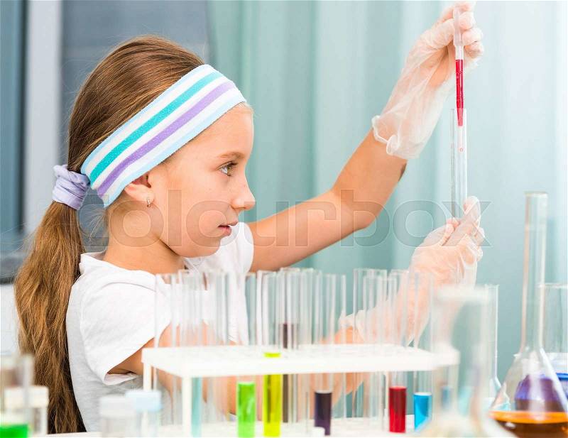 Cute little girl with flasks for chemistry, stock photo