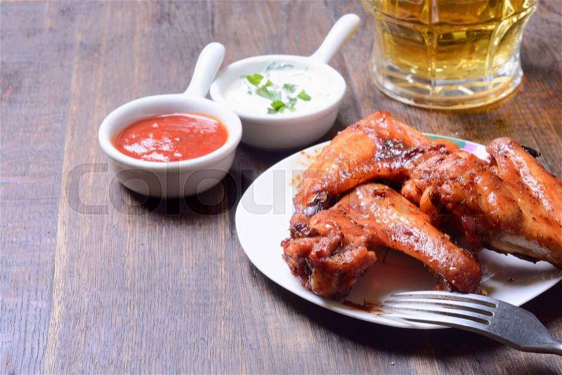 Baked meat wings on wooden background, stock photo