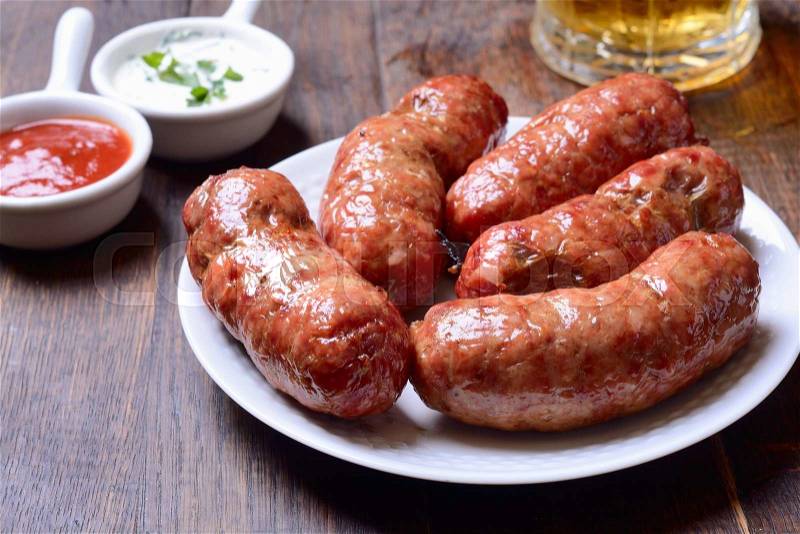 Baked meat sausage on wooden background, stock photo