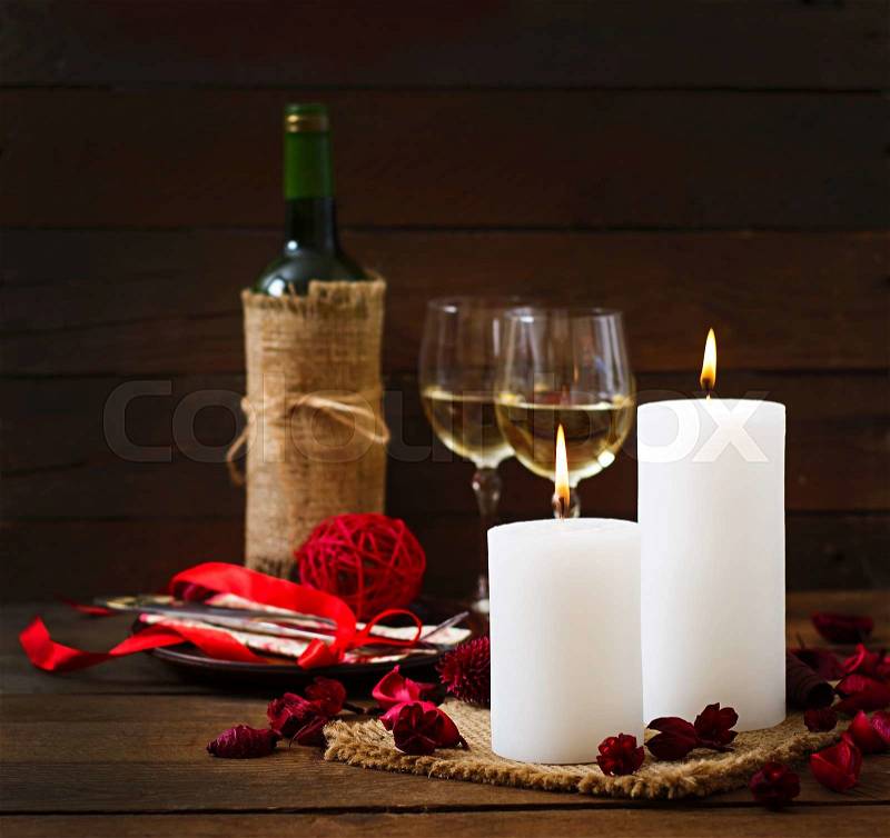 Romantic dinner setting, candles, wine and decor, stock photo