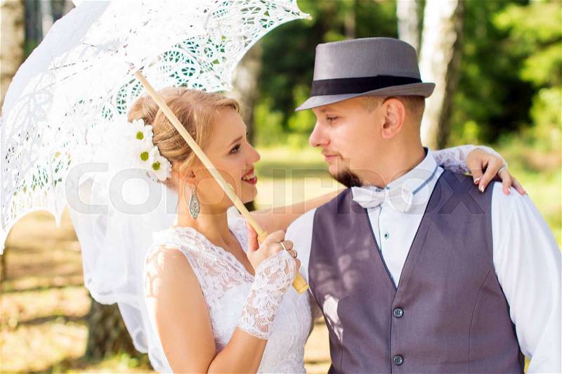 Bride and groom looking at each other in the woods, stock photo
