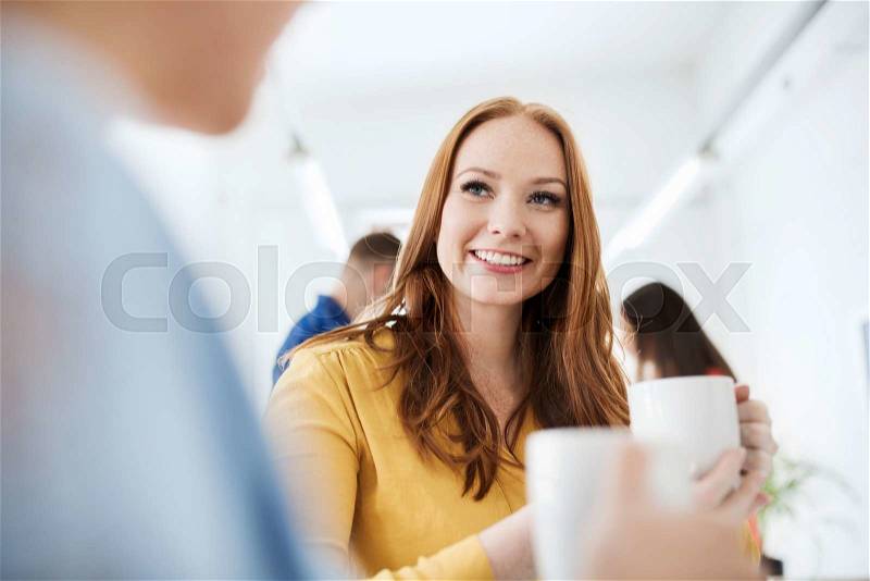 Business, startup and people concept - happy creative team or students drinking coffee at office, stock photo