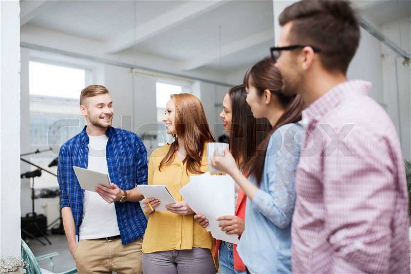 Business, communication, startup and people concept - happy international creative team or students on coffee break talking at office, stock photo