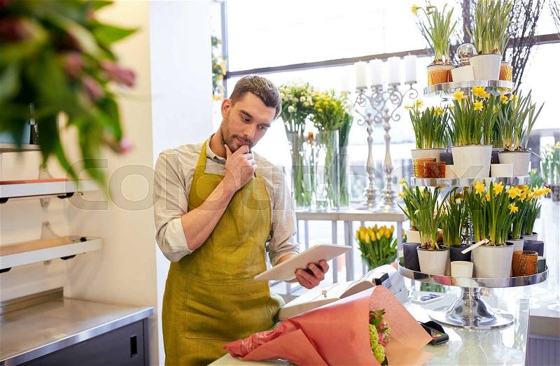 People, business, technology, sale and floristry and concept - florist man with tablet pc computer thinking at flower shop counter, stock photo