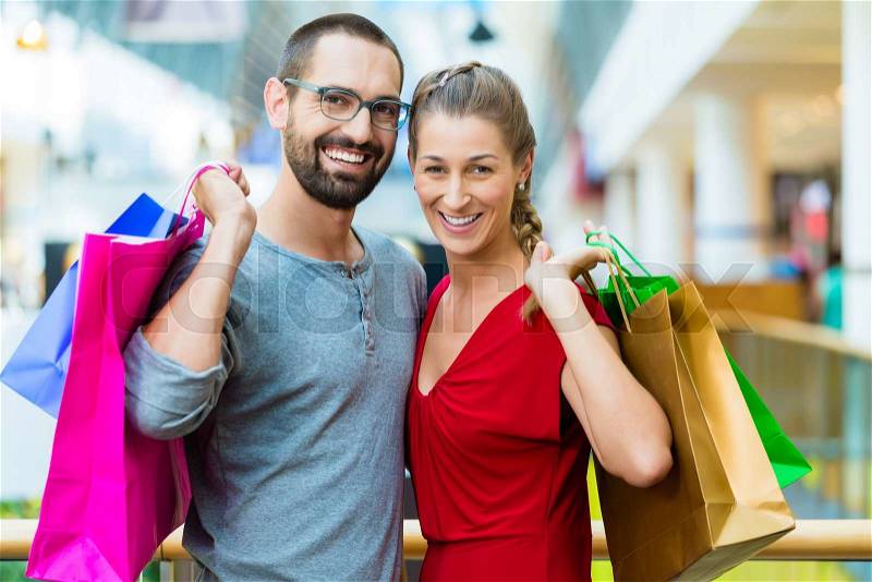 Couple, man and woman, in modern shopping mall with bag, stock photo