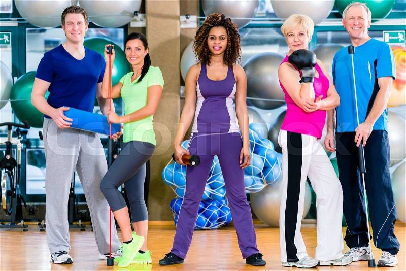 Diversity fitness group in gym, old and young, black and white people, doing sport in gymnastic training, stock photo