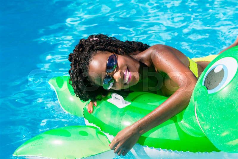 Girls in swimming pool water with inflatable anmimal, stock photo