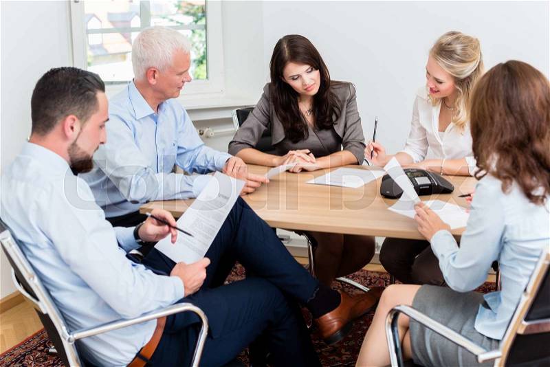 Lawyers having team meeting in law firm reading documents, stock photo