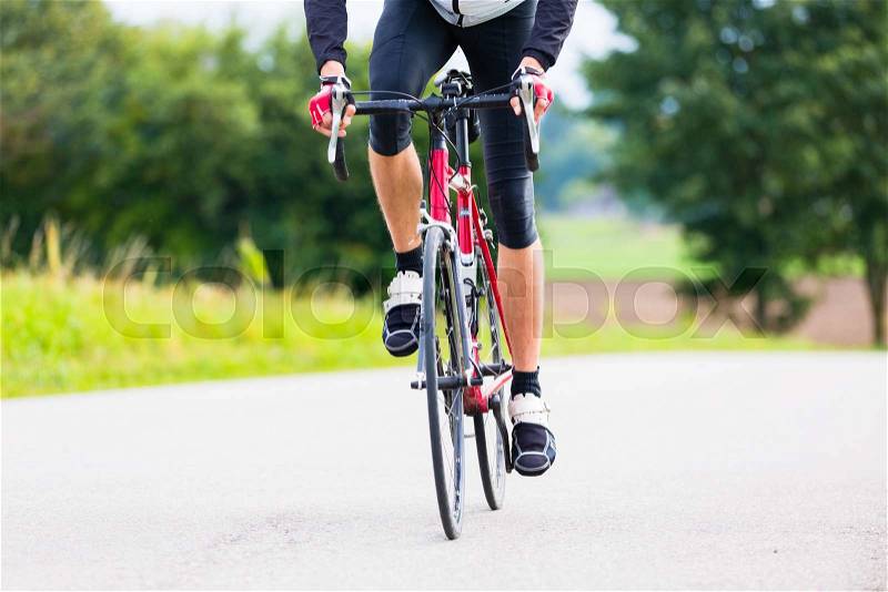 Cyclist on race bike pedaling on bike track outdoors, stock photo